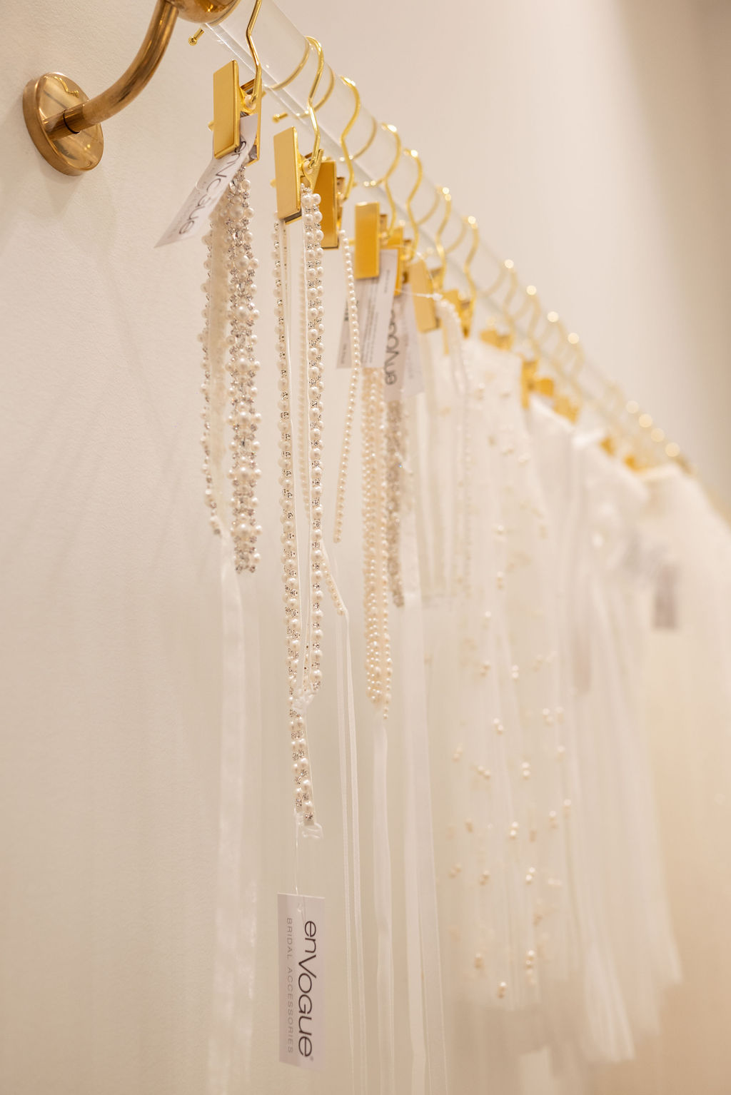 Bridal Lace Accessories Collection Close-up of delicate white lace bridal accessories displayed on gold hangers