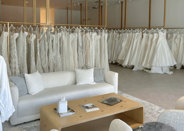 Luxury bridal boutique showroom with rows of wedding dresses and a modern seating area