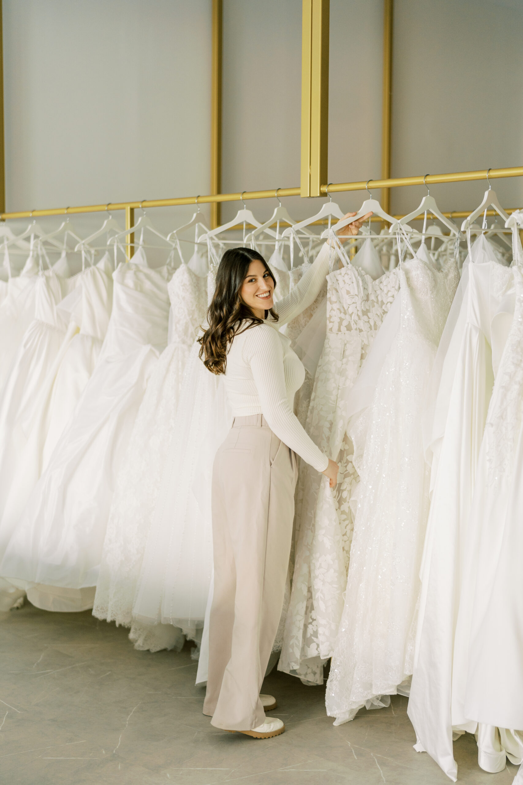 Hailey Nicole Bridal Bride smiling in a white wedding dress while browsing bridal gowns at Hailey Nicole Bridal